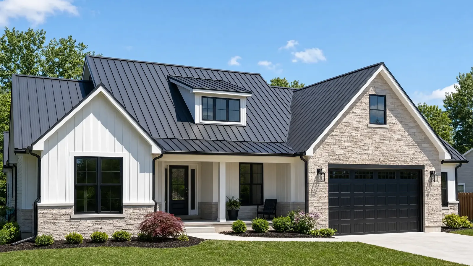 A modern farmhouse with a black standing-seam metal roof under a clear sky